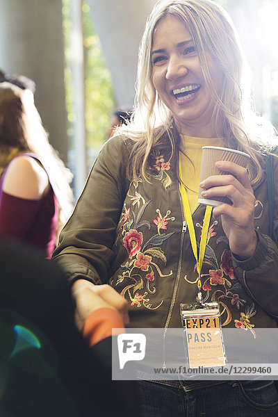 Smiling woman with coffee at conference