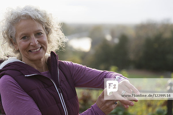 Portrait smiling  confident active senior woman exercising  checking smart watch
