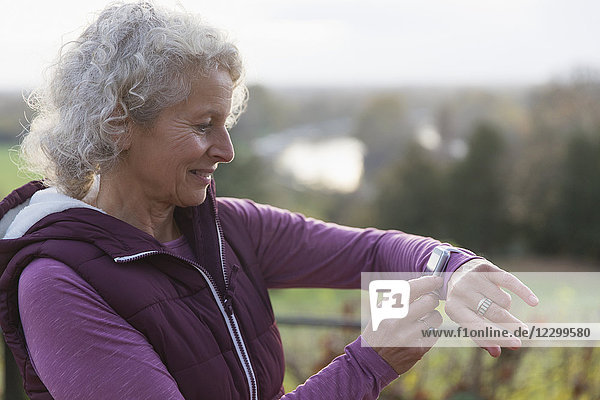 Active senior woman exercising  using fitness tracker smart watch