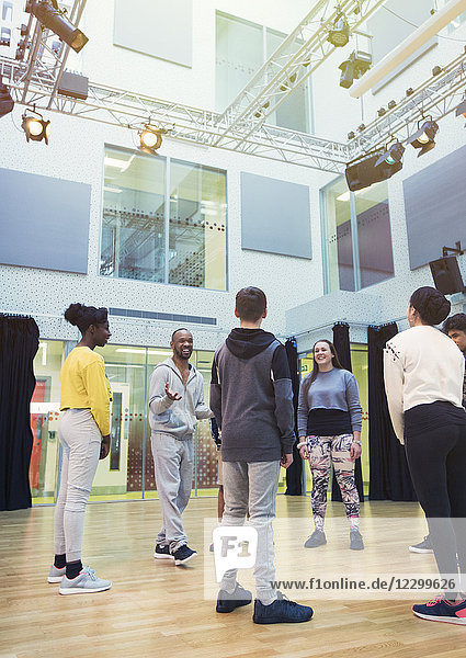 Teenage students listening to male instructor in dance class studio