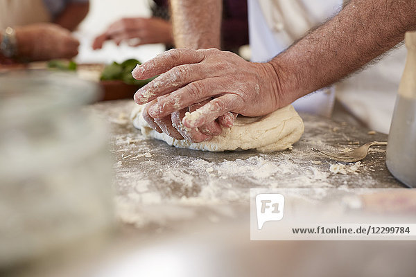 Close up man kneading pizza dough