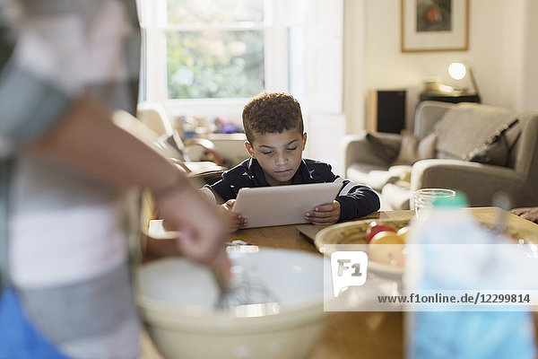 Curious boy using digital tablet in kitchen