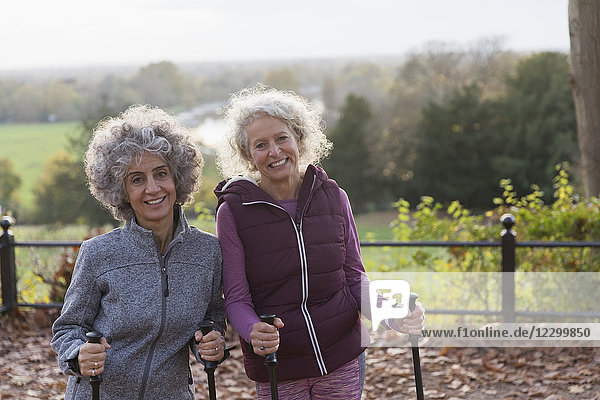 Portrait smiling  confident active senior women friends hiking with poles