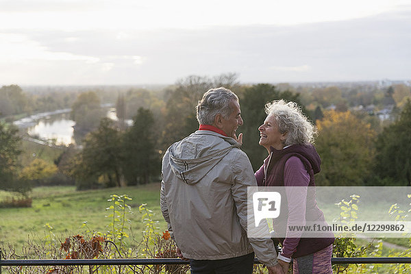 Smiling  affectionate active senior couple in autumn park