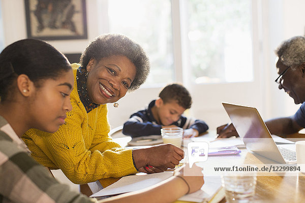 Portrait smiling  confident grandmother helping granddaughter with homework