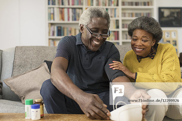 Smiling senior couple checking blood pressure