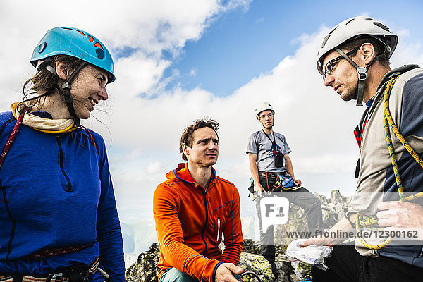 Gruppe von vier Bergsteigern mit Frau und drei Männern  die sich bei einer Rast unterhalten  Tatra-Gebirge  Slowakei