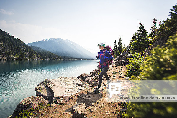 Woman hiking along shore of Lake Garibaldi  British Columbia  Canada