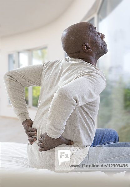 Ein Mann leidet unter Schmerzen im unteren Rückenbereich.