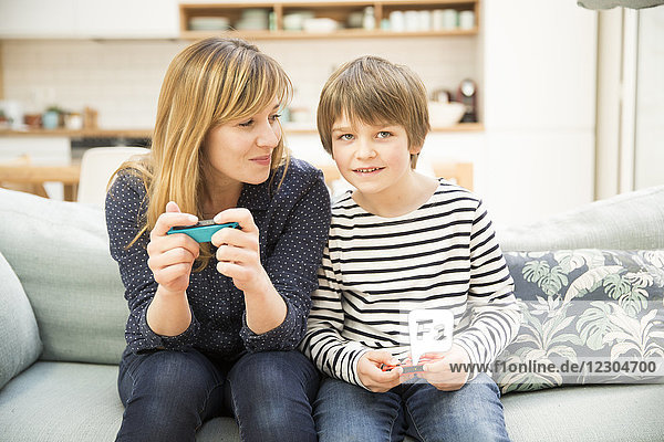 Mutter und Sohn spielen ein Videospiel.