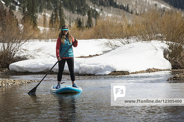 Frontansicht einer Frau beim Paddeln auf einem Fluss im Winter  Aspen  Colorado  USA