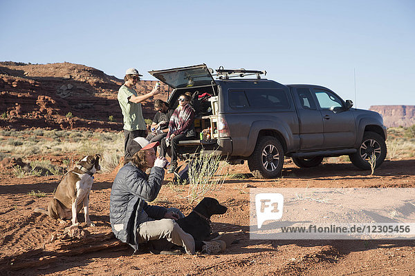 Gruppe von Bergsteigern mit Hunden in der Nähe eines Lastwagens in der Wüste nach einem Aufstieg  Moab  Utah  USA