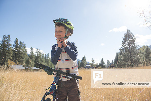 A young boy puts his helmet on for a bike ride in Mazama Wa.