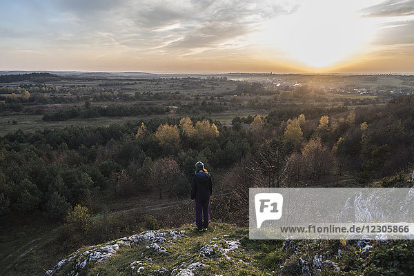 Rückansicht einer jungen Frau mit Blick auf einen schönen Wald auf einem Hügel bei Sonnenuntergang  Polnischer Jura  Rzedkowice  Schlesien  Polen