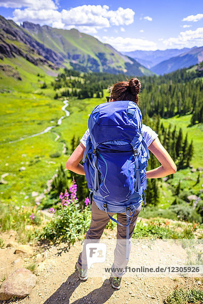 Rear view shot of female backpacker looking out over Ice Lakes Basin  Ice Lakes Trail  Colorado  USA