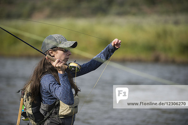 Female angler casting line in Colorado River  Colorado  USA