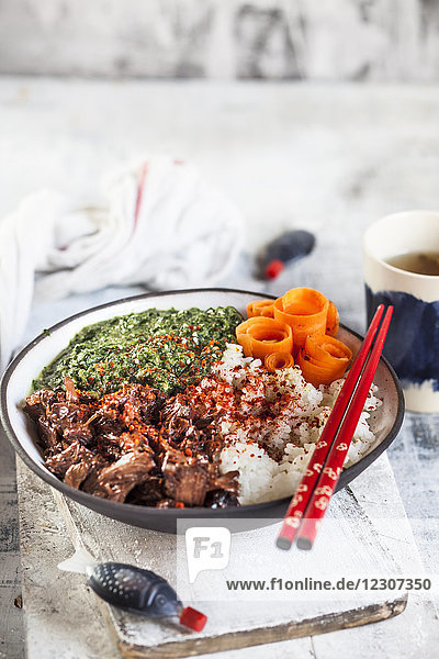 Vegane Teriyaki-Schale mit gezogenem Teriyaki-Rindfleisch aus Jackfrucht  Spinat  Reis und Karotten