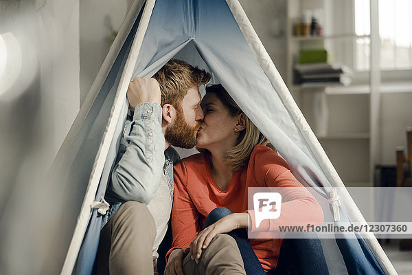 Glückliches Paar zu Hause Camping in einem Zelt im Wohnzimmer