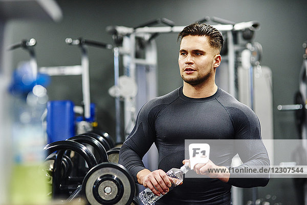Mann macht Pause im Fitnessstudio