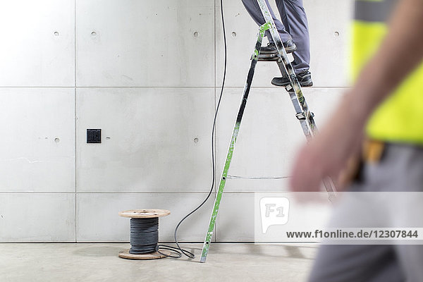 Partial view of electricians at work on construction site