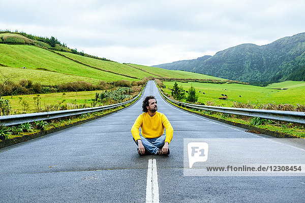 Azores  Sao Miguel  Man sitting on an empty road