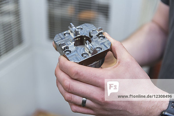 Close-up of man holding workpiece in factory