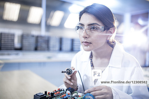 Female technician working on motherboard