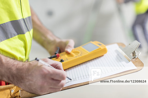 Close-up of electrician taking notes