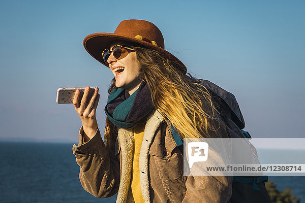 Italien  Sardinien  lachende Frau auf einem Wanderausflug mit Handy