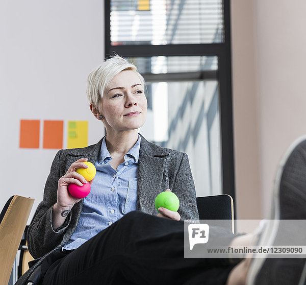 Geschäftsfrau mit Jonglierbällen im Amt