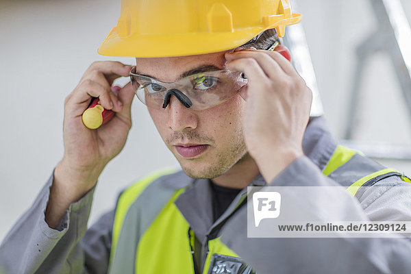 Electrician putting on protective glasses