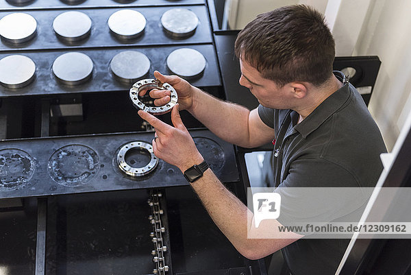 Man examining workpiece in factory