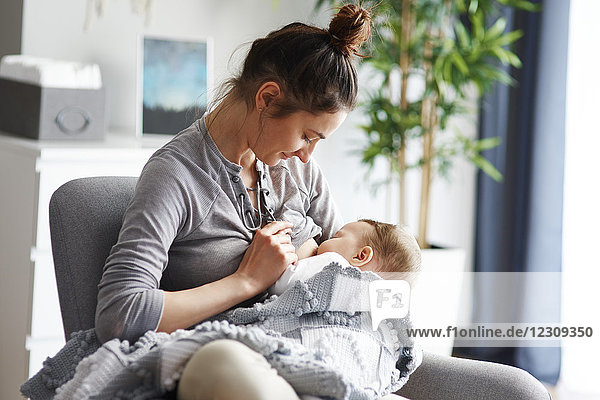 Mother breastfeeding her baby at home