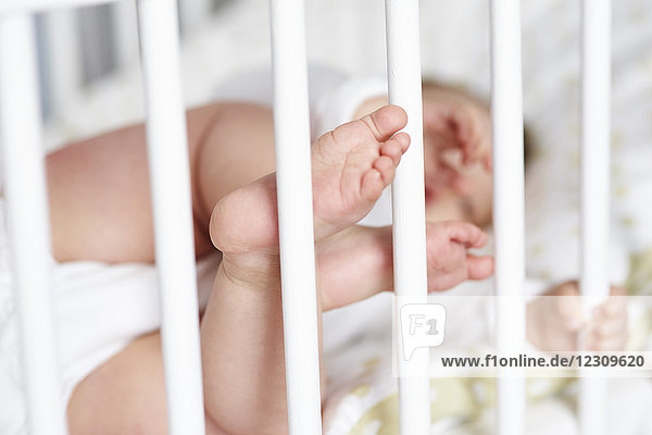 Nahaufnahme von winzigen Babyfüßen in der Krippe