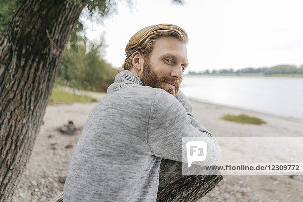 Deutschland  Düsseldorf  Portrait eines zufriedenen Mannes  der sich am Strand entspannt