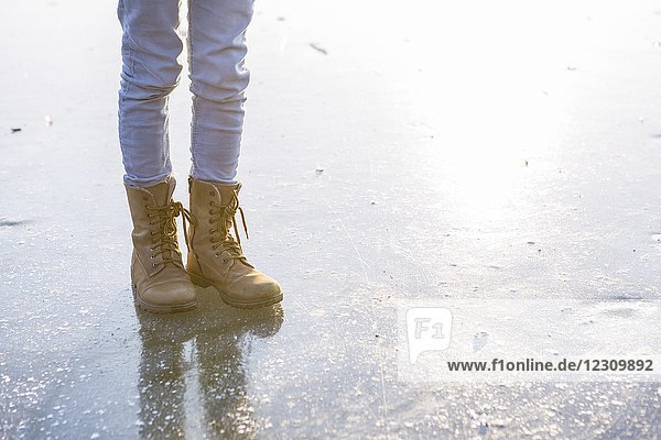 Deutschland  Brandenburg  Straussee  Füße mit Stiefeln auf gefrorenem See