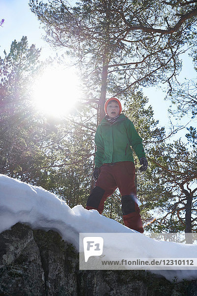 Porträt eines Jungen  stehend in schneebedeckter  ländlicher Landschaft  Blick aus niedrigem Winkel