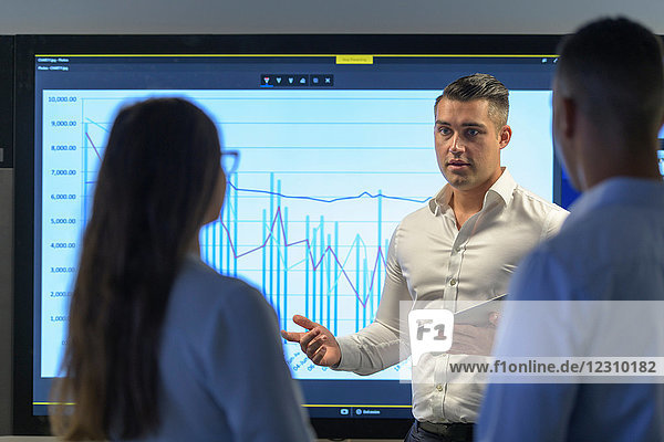 Man presenting business meeting with graph on screen