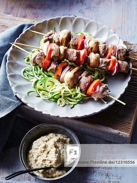 Lamb souvlaki skewers  with courgette noodles and baba ganoush  close-up