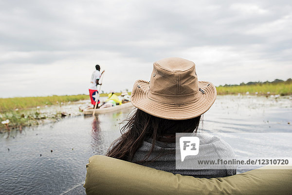 Junge Frau im Kanu auf dem Okavango-Delta  Rückansicht  Botswana  Afrika