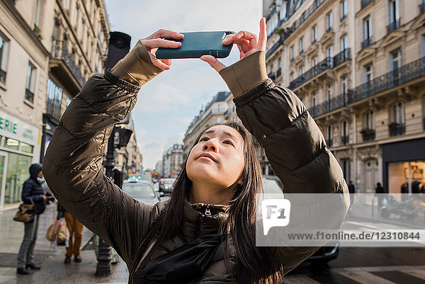 Junge Frau mit Smartphone-Selfie auf der Straße in der Stadt  Paris  Frankreich