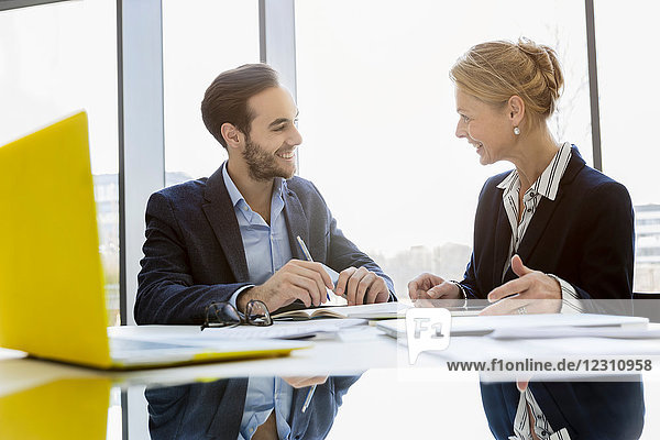 Colleagues in business meeting face to face smiling