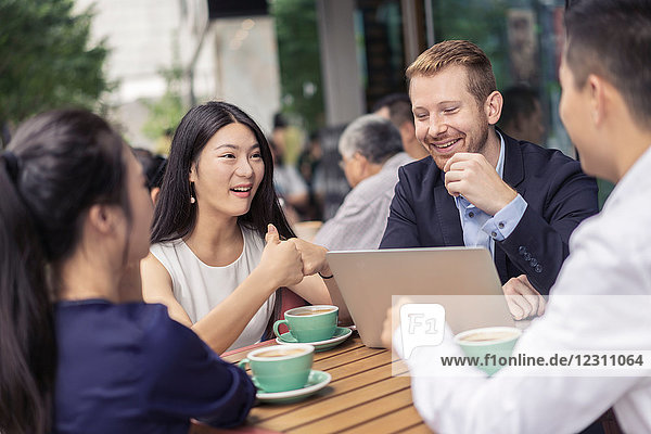 Gruppe von Geschäftsleuten  die sich im Café treffen  Laptop benutzen  im Freien