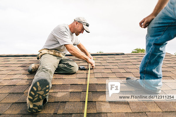 Zwei Arbeiter auf dem Dach  Vorbereitung zur Installation von Solarpaneelen  niedriger Blickwinkel