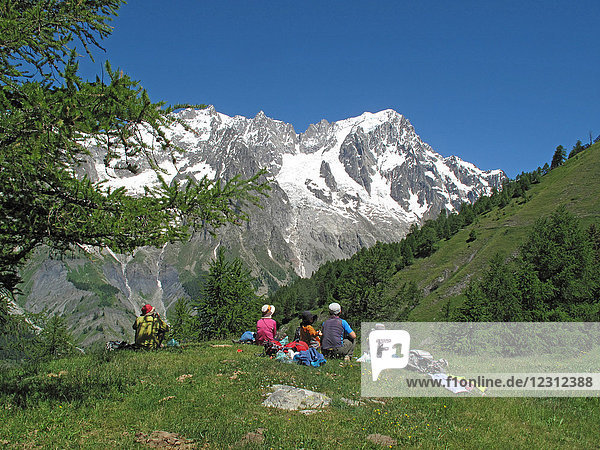 Italia Aoste valley  Ferret valley Courmayeur  a group of hikers is sharing a piknic on the tour du mont blanc trail in front of the italian side of the mont blanc range