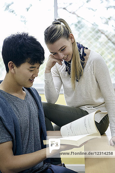 Students looking at textbook together
