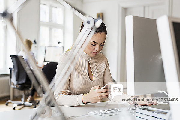 Businesswoman using phone in office