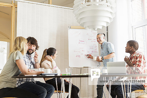 Coworkers discussing project in board room