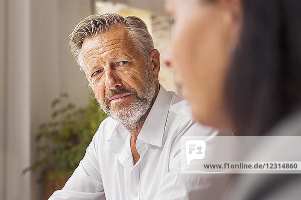 Senior man and mature woman talking in cafe