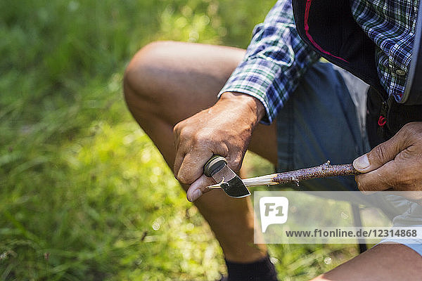 Man sharpening stick